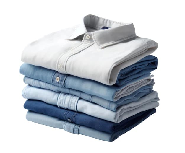 Colorful stack of neatly folded laundry including shirts, t-shirts, and jeans in various soft colors